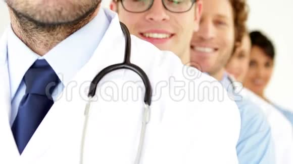 一队医生站在一旁对着镜头微笑视频的预览图