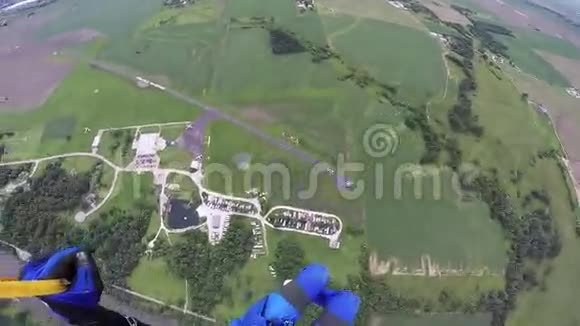 专业跳伞员跳伞在蓝天之上的绿色平原风景视频的预览图