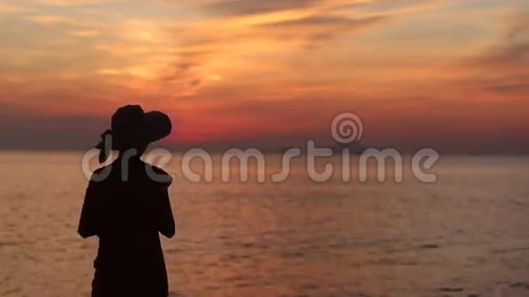 戴帽子的女孩剪影拍摄海上日出视频的预览图