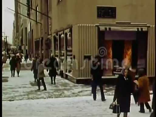 纽约市BonwitTeller在白雪覆盖的人行道上行走的行人视频的预览图