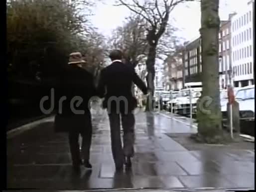 从后视角射了两个男人走在城市街区视频的预览图