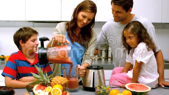 一家人在搅拌机里倒水果鸡尾酒的女人视频的预览图