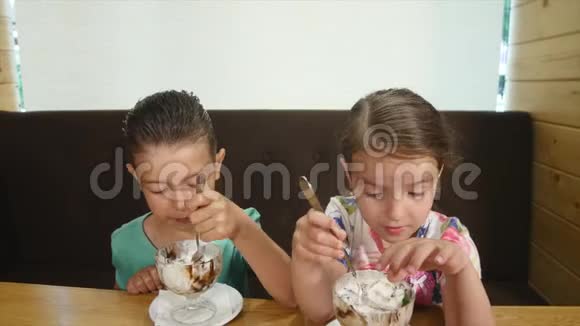 快乐的小女孩和男孩在咖啡馆吃冰淇淋视频的预览图