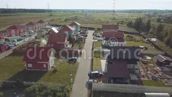 空中勘测丘陵间的乡村山谷飞越红色屋顶的小房子视频的预览图