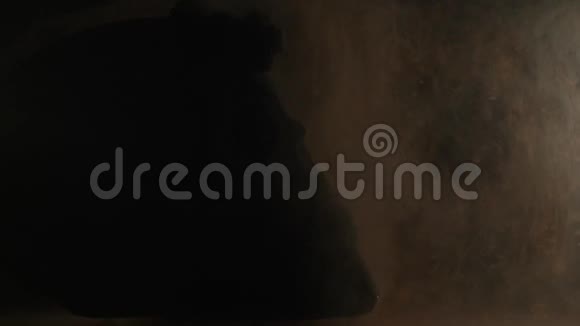 黑色背景下的骷髅在水中涂上彩色墨水视频的预览图