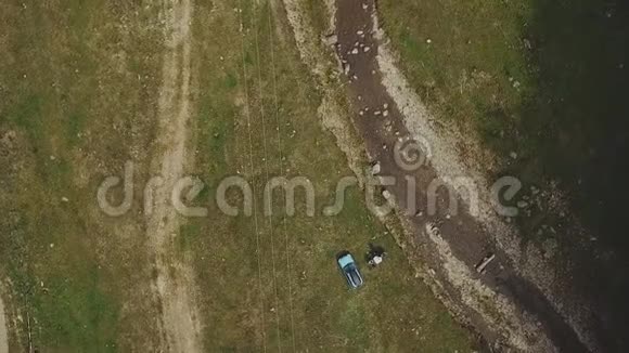 空中观车骑在路上的针叶林中的群山游客在汽车附近自拍视频的预览图