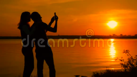 日落时分年轻夫妇在海滩上自拍动作非常慢视频的预览图