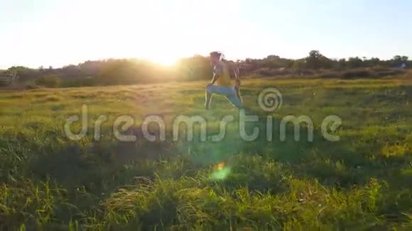 年轻人坐在草地上的草地上做瑜伽运动肌肉男在大自然中伸展身体视频的预览图
