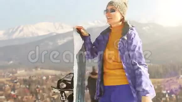 高山滑雪季节有滑雪板的漂亮女孩视频的预览图