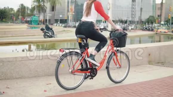 骑自行车在棕榈树旁蹬车的年轻女子或女孩视频的预览图