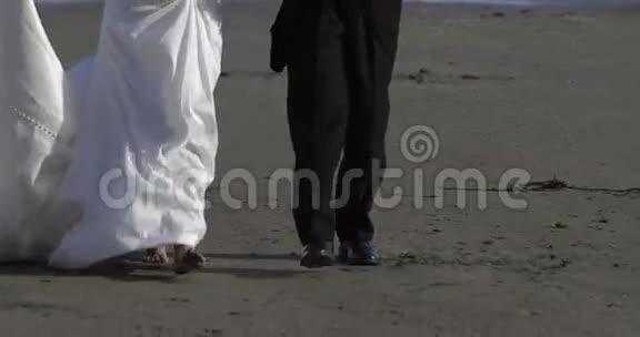 微笑的新婚夫妇在海滩上散步视频的预览图