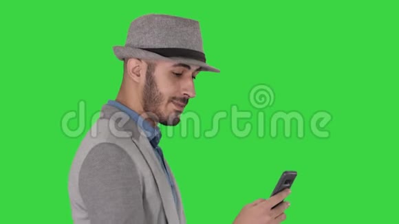偶然的人在电话上发短信在绿色屏幕上行走Chroma键视频的预览图