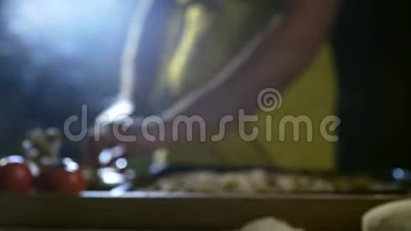 年轻厨师为披萨切桌上的橄榄视频的预览图