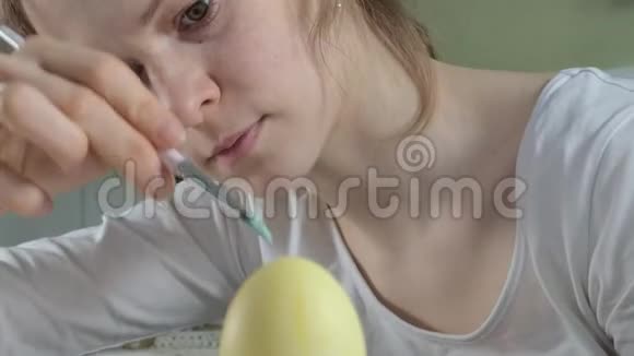 一个女人用彩色颜料和特写画复活节彩蛋视频的预览图