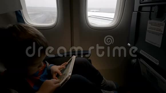 在飞机上使用平板电脑的男孩视频的预览图