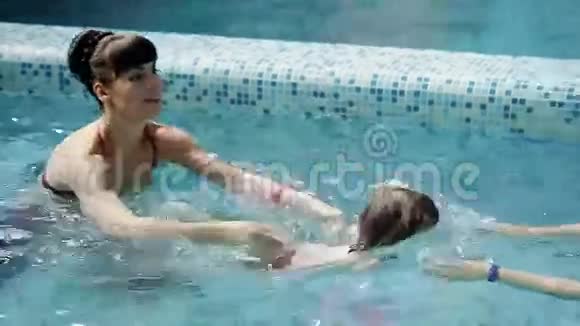 父母教儿子在游泳池里游泳视频的预览图
