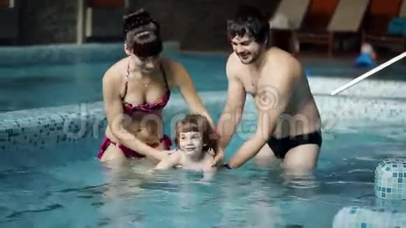 父母教儿子在游泳池里游泳视频的预览图