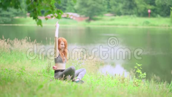 美丽苗条的女人在公园里练习瑜伽视频的预览图