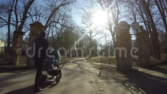 春天带着蓝色婴儿车的人走复古公园大门4K视频的预览图