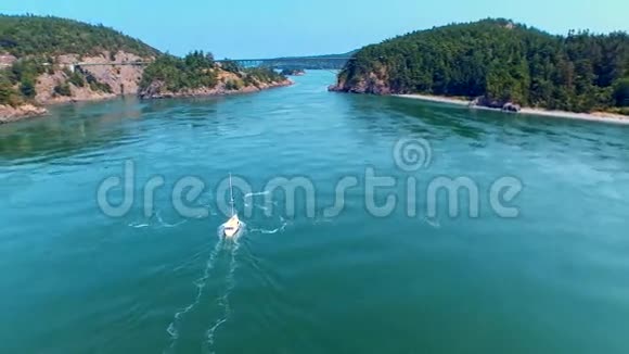 阳光明媚的一天帆船驶向海滨海湾的桥视频的预览图