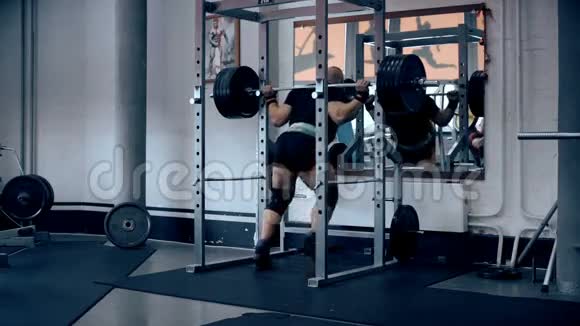男性健美运动员在健身房用杠铃做蹲视频的预览图