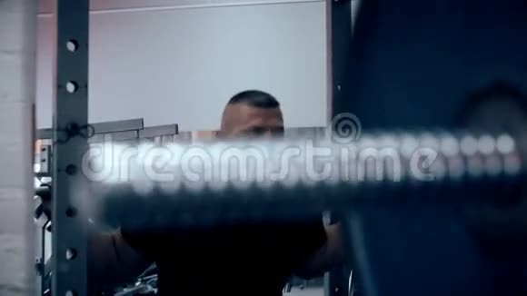 男性健美运动员在健身房用杠铃做蹲视频的预览图
