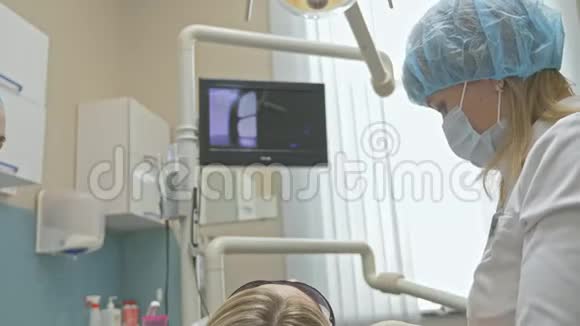 医生用特殊的口腔检查数字微相机检查牙齿监控牙医和病人看录像视频的预览图
