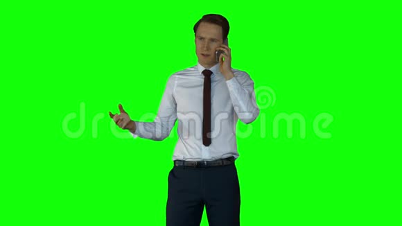 愤怒的商人在绿色屏幕上打电话视频的预览图