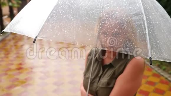 一个女人站在伞下夏天倾盆大雨4k慢镜头视频的预览图