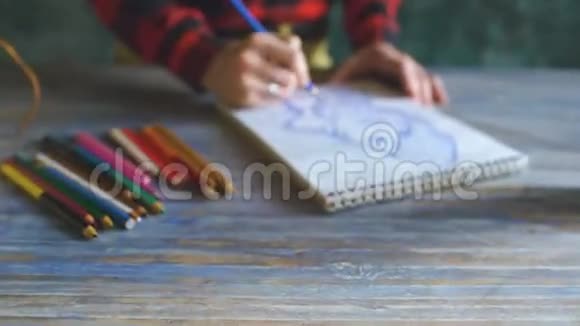 年轻女子艺术家用铅笔特写在纸笔记本上作画视频的预览图