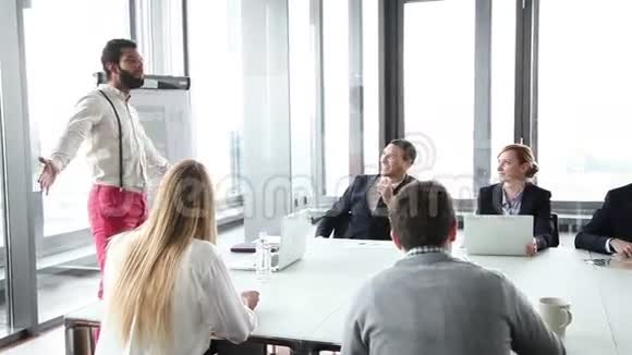 商务人士坐在餐桌旁而男性同事则在做演讲视频的预览图