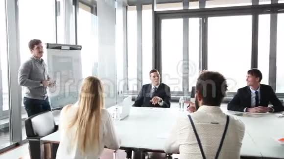 商务人士坐在餐桌旁而男性同事则在做演讲视频的预览图