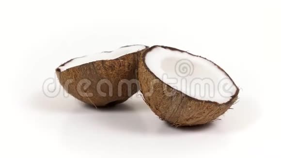 两个成熟的椰子半部分美味的果肉旋转在白色孤立的背景可循环无缝视频的预览图