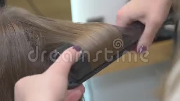 美发师在美女金发上做发型特写视频的预览图