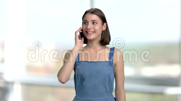 年轻兴奋的女人在电话里说话视频的预览图