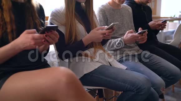 一群人在咖啡馆里使用手机而不是互相交流视频的预览图