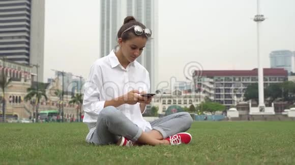 年轻女商人在智能手机上工作写留言视频的预览图