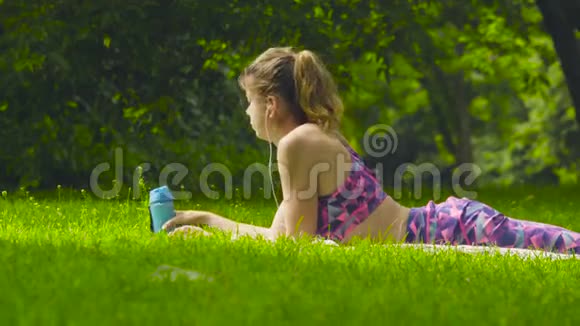 躺在公园草地上的年轻女子视频的预览图