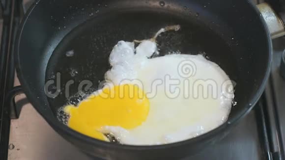 在平底锅里煎鸡蛋滑雪板站在滚刀上特写视频的预览图