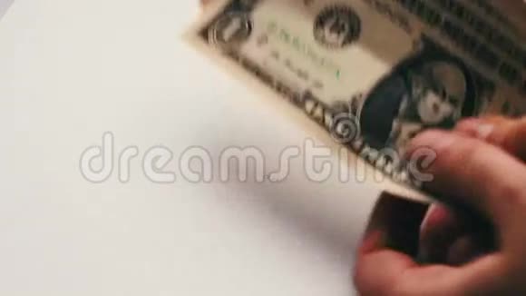 女人数着桌上的一小块美元钞票白色背景的宏观特写视频的预览图