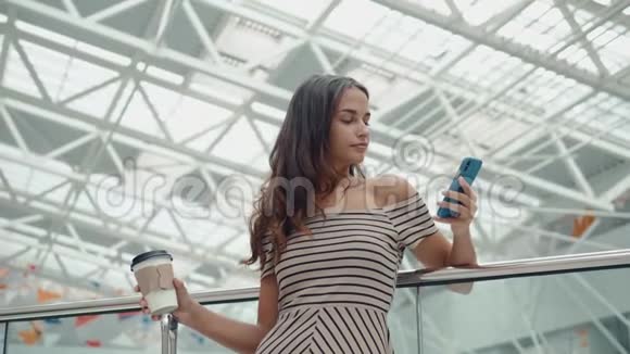 购物妇女微笑着拿着袋子在商场的电话里交谈有智能手机的漂亮女孩视频的预览图