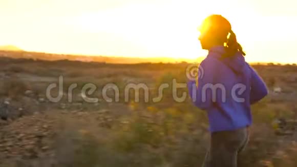 日落时女人沿着废弃的沥青路奔跑背景上的山脉视频的预览图