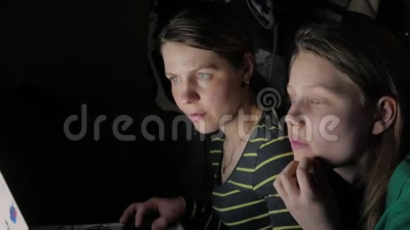 母女俩坐在笔记本电脑前一起玩4KUHD视频的预览图