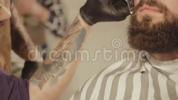 变得完美理发店理发师剪胡子的年轻留胡子男子的近景视频的预览图
