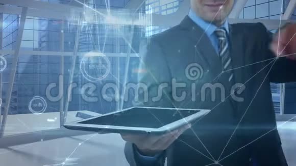 商人拿着并触摸一台数字平板电脑它的前景上连接着数据视频的预览图