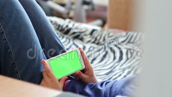 在家里的沙发上用智能手机发色键上网的青少年视频的预览图