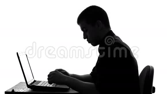 年轻商人在笔记本电脑里工作的剪影视频的预览图