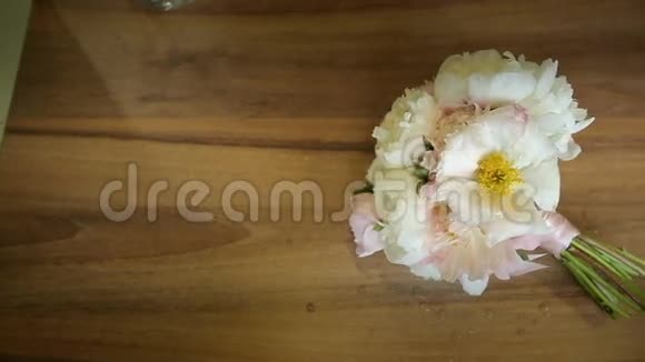 木桌上系着一束粉红色丝带的白色花朵投中弹视频的预览图