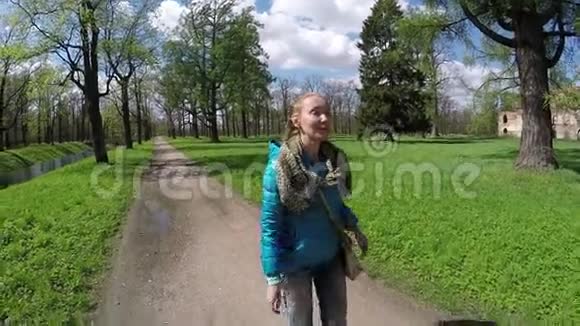 那个漂亮的女人在绿色公园的路上走视频的预览图