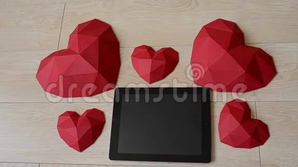 三个红色的多角形纸心形在木桌上视频的预览图